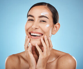 Canvas Print - Portrait, hands and cream with a woman in studio to apply treatment on a blue background for beauty. Face, skincare and lotion with an attractive young female posing to promote a luxury product