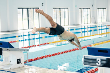 Canvas Print - Sports, swimming pool and man diving in water for training, exercise and workout for competition. Fitness, wellness and professional male athlete in action for dive, jump and race from diving board