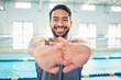 © Clayton D/peopleimages.com - Portrait, stretching and man at swimming pool for training, cardio and exercise, indoor and flexible. Face, smile and swimmer stretch before workout, swim and fitness routine, warm up and preparation