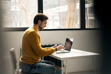 Wall Mural - Portrait of young man sitting at his desk in the office