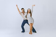© master1305 - Positive vibes. Young beautiful girl in silver dress and stylish man dancing disco dance isolated over grey studio background. 70s fashion, hobby, creativity, hippie lifestyle, American culture