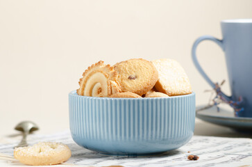 Close up of Cookies on blue cup on light spring background with vintage paper. Spring theme.