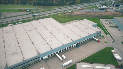 Sticker - Buildings of logistics center, warehouses near the highway, view from height, a large number of trucks in the parking lot near warehouse.