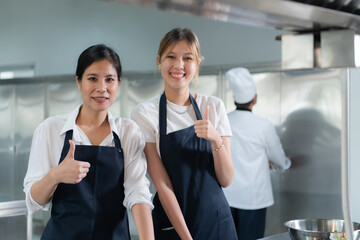 Cooking apprentices prepare meals and ingredients before the chef arrives to instruct at the culinary academy's kitchen.