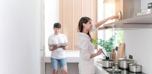 Wall Mural - happy asian couple cooking healthy food. smiling boyfriend and girlfriend making breakfast support each other. attractive wife and cheerful husband preparing delightful meal with fresh ingredients