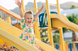 © Maria - Child playing on outdoor wooden playground. Kids play on school or kindergarten yard. Active kid on colorful slide. Healthy summer activity for children