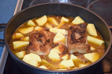 Wall Mural - Schweinebacuhpfanne mit Apfelsauce und Kartoffeln, noch kochend