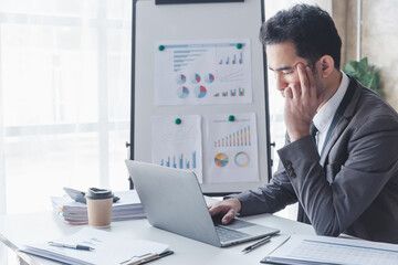 Finance and investment concept, Businessman feel stress while colleagues discussing new investment plan by financial graph data on office table with laptop and digital tablet.