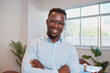 © Meeko Media - Close up Black businessman poses with arms folded in office