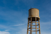 Old Water Storage Tank Isolated With Blue Sky