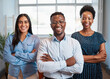 © Meeko Media - Group of smiling business people pose arms folded in office, diverse trio
