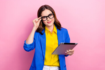 Poster - Photo of young confident business lady touch glasses wear stylish ukrainian style formal outfit hold lenovo tablet isolated on pink color background