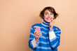 © deagreez - Photo of adorable positive person finger touch lips hold telephone look empty space isolated on beige color background
