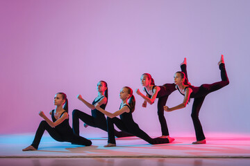 Wall Mural - group of five teenagers balrins in black tight-fitting costumes are dancing modern konteporari on a lilac background