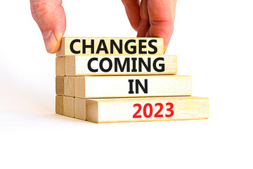 Wall Mural - Changes coming in 2023 symbol. Concept word Changes coming in 2023 on wooden blocks. Businessman hand. Beautiful white table white background. Business and changes coming in 2023 concept. Copy space.