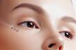 © Mirrorstudio - Applying clear serum to young woman's face. Skin care, cosmetics and health