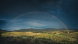 Fototapeta Tęcza - Rainbow in countryside landscape. Bibbona, Tuscany, Italy.