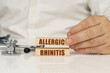 On a white surface, a stethoscope and wooden plates with the inscription - allergic rhinitis