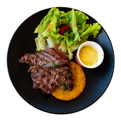 French traditional dish. Fried beef with salad of vegetables and herbs served on plate. Onglet de bouef. Isolated over white background