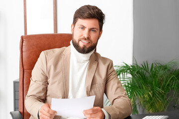 Wall Mural - Handsome young businessman working with document at table in office