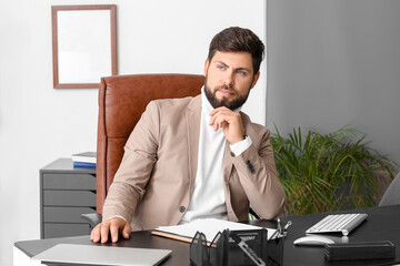 Sticker - Handsome businessman sitting at table in office