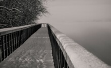 Snowy Bridge With Footprints Over Water Black And White