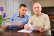 © JackF - Elderly man and sales manager signing contract of purchase at home. High quality photo