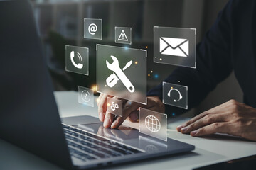 businessman using laptop with helpdesk icon on screen, hotline assistance service available by phone