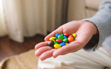 Closeup image of a hand holding colorful chocolate candy