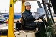 © DRN Studio - Middle-aged Asian male worker with forklift on factory grounds.