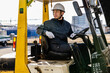 © DRN Studio - Middle-aged Asian male worker with forklift on factory grounds.