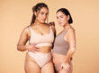 © Nina L/peopleimages.com - Confidence, empowerment and portrait of women in underwear isolated on a studio background. Sexy, support and models in lingerie for body positivity, comparison and acceptance on a beige backdrop