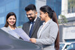 © G-images - Group of businesspeople going through a report at work