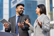 © G-images - Business colleagues having fun using digital tablet outdoors in city