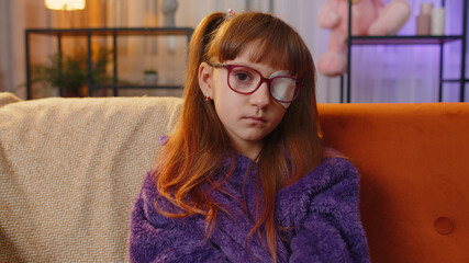 sick ill preteen girl looking at camera, having protective bandage plaster patch scratch on one eye.