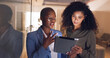 © S Fanti/peopleimages.com - Black women, business and tablet in discussion or meeting for corporate strategy, planning or collaboration at office. African woman executive talking to employee on touchscreen technology at work