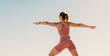 Woman practicing warrior pose outdoors in sportswear for physical fitness, wellbeing and health