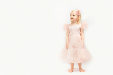 pretty little girl in festive princess dress stands barefoots. blonde princess isolated on white bac