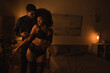 © LIGHTFIELD STUDIOS - young man touching sexy african american girlfriend in black lingerie in dark bedroom with lighting