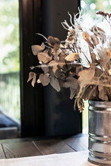 Beautiful still life with dried flowers in a tin can by the window