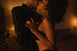 © LIGHTFIELD STUDIOS - young man in black shirt hugging and kissing sexy african american girlfriend in dark bedroom