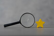 © Dontree - A black magnifying glass with a yellow star. The concept of finding the star, find a new actor. Hiring and recruitment selection. Career opportunity. Human resource management.