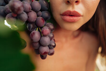 Young woman holding a bunch of grapes at vineyard
