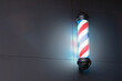 Brillando en la oscuridad: imagen de un poste de barbero luminoso en un entorno oscuro
