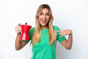 Wall Mural - Young Uruguayan woman holding coffee pot isolated on white background with surprise facial expression