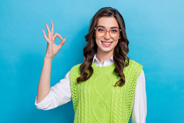 Poster - Portrait of positive charming girl toothy smile hand fingers demonstrate okey symbol isolated on blue color background