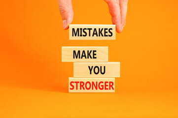 Wall Mural - Mistake make stronger symbol. Concept words Mistakes make you stronger on wooden blocks. Beautiful orange background. Businessman hand. Business mistake make stronger concept. Copy space.