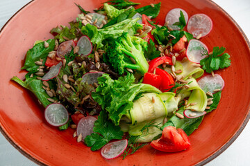 Wall Mural - Summer vegetable salad with zucchini, tomatoes, radishes, broccoli and sunflower seeds