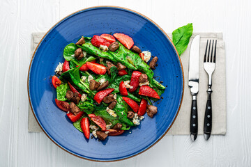 Wall Mural - Salad with fried duck liver, brie cheese, strawberries, tomatoes and spinach leaves