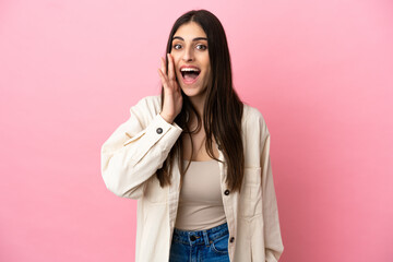 Wall Mural - Young caucasian woman isolated on pink background with surprise and shocked facial expression